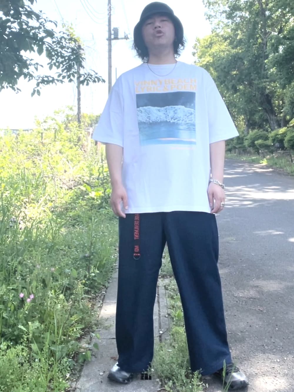 ホワイト系のTシャツ/カットソー、ブルー系のデニムパンツ、シルバー系のスニーカーを着用したメンズの春コーディネートの2枚目の写真