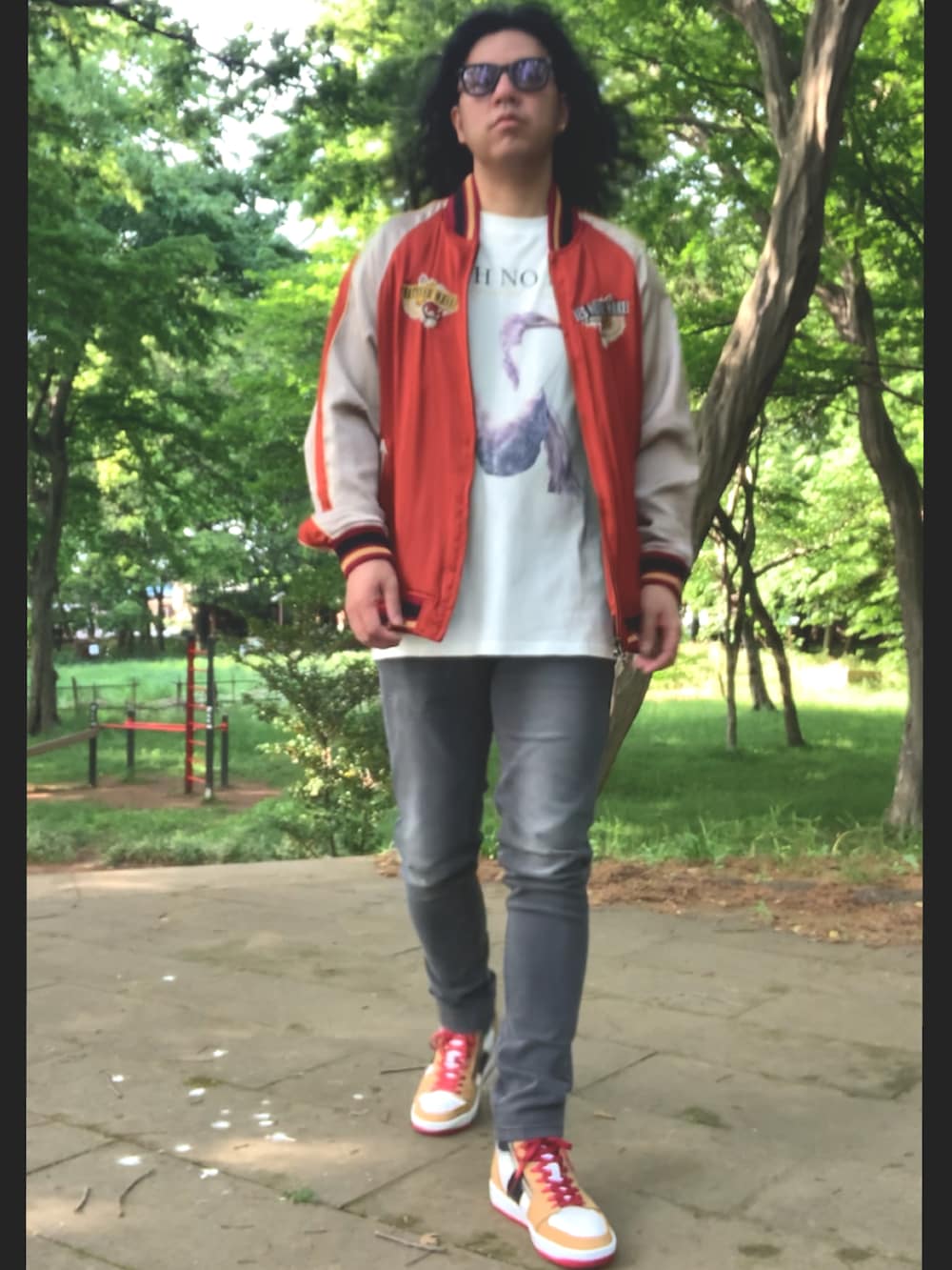 グレー系のデニムパンツ、ホワイト系のTシャツ/カットソー、レッド系のスカジャンを着用したメンズの春コーディネートの2枚目の写真