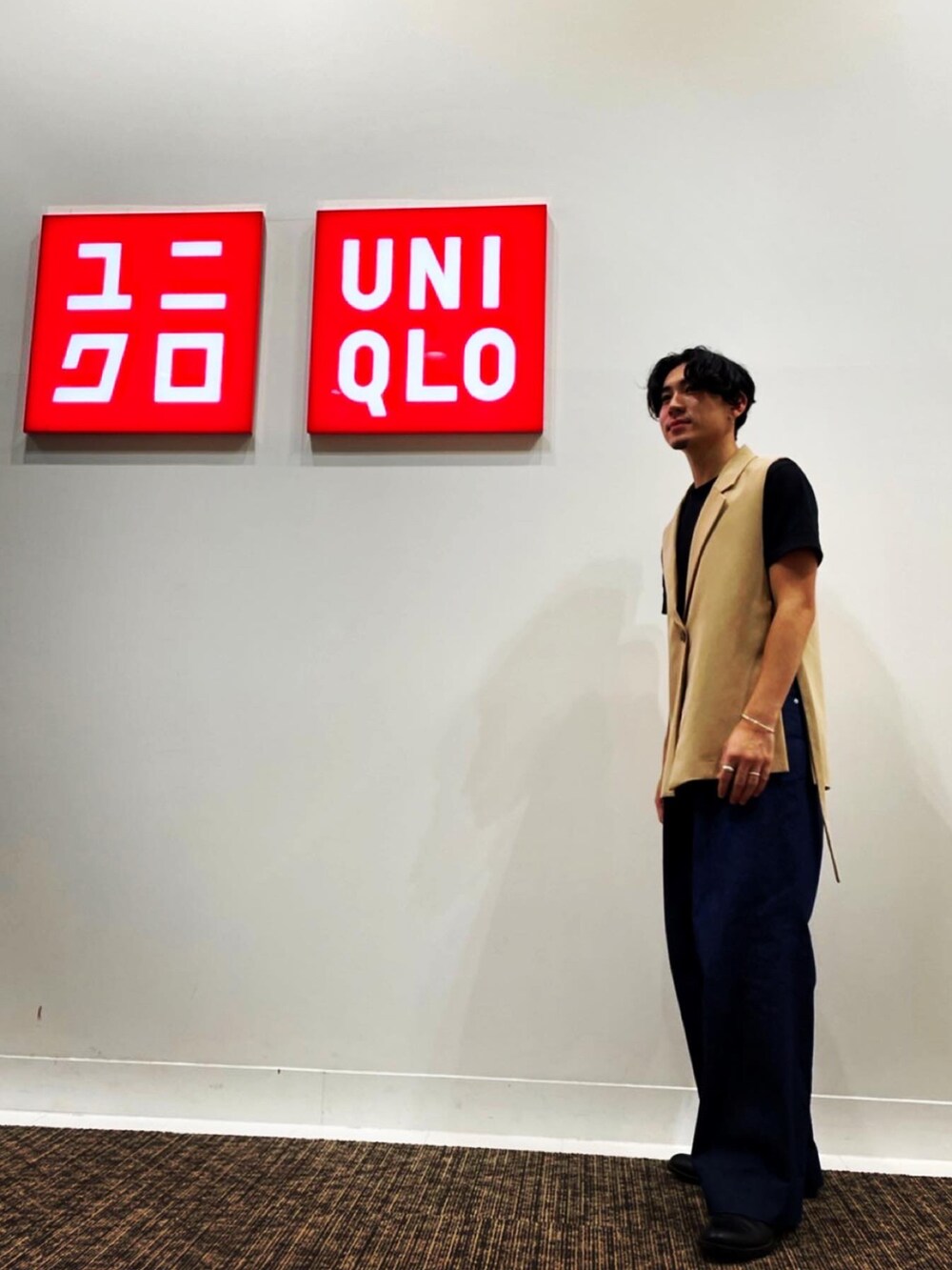 ベージュ系のベスト、ブラック系のTシャツ/カットソー、ブルー系のデニムパンツを着用したメンズの冬コーディネートの2枚目の写真