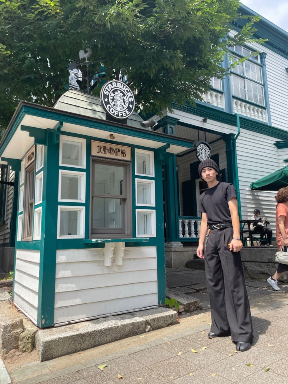 ブラック系のTシャツ/カットソー、ブラック系のスラックス、ブラック系のブーツを着用したメンズの夏コーディネートの3枚目の写真