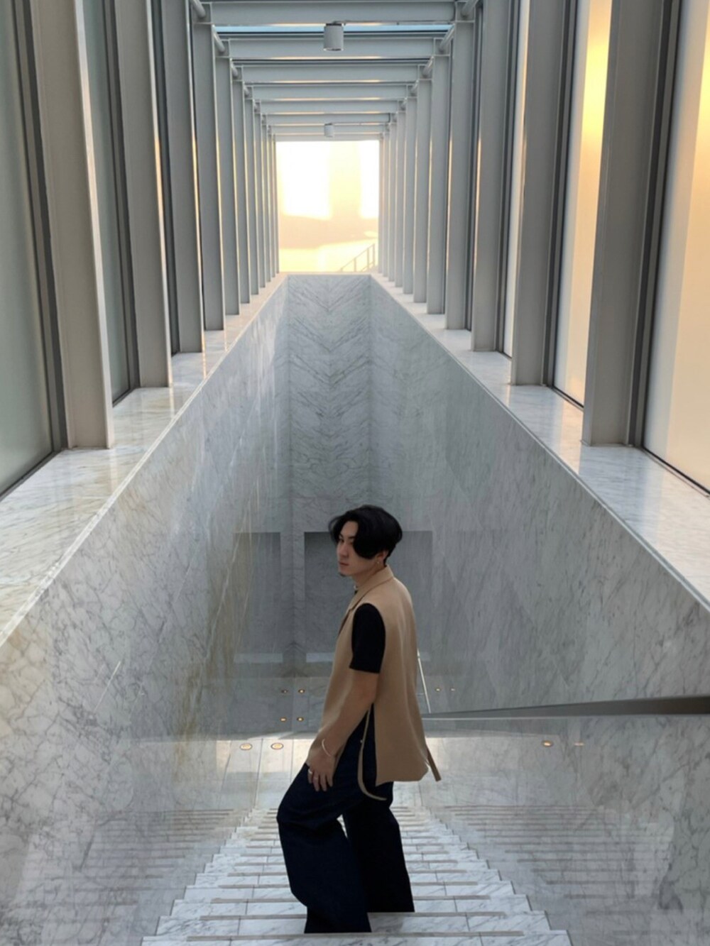 ベージュ系のベスト、ブラック系のTシャツ/カットソー、ブルー系のデニムパンツを着用したメンズの冬コーディネートの3枚目の写真