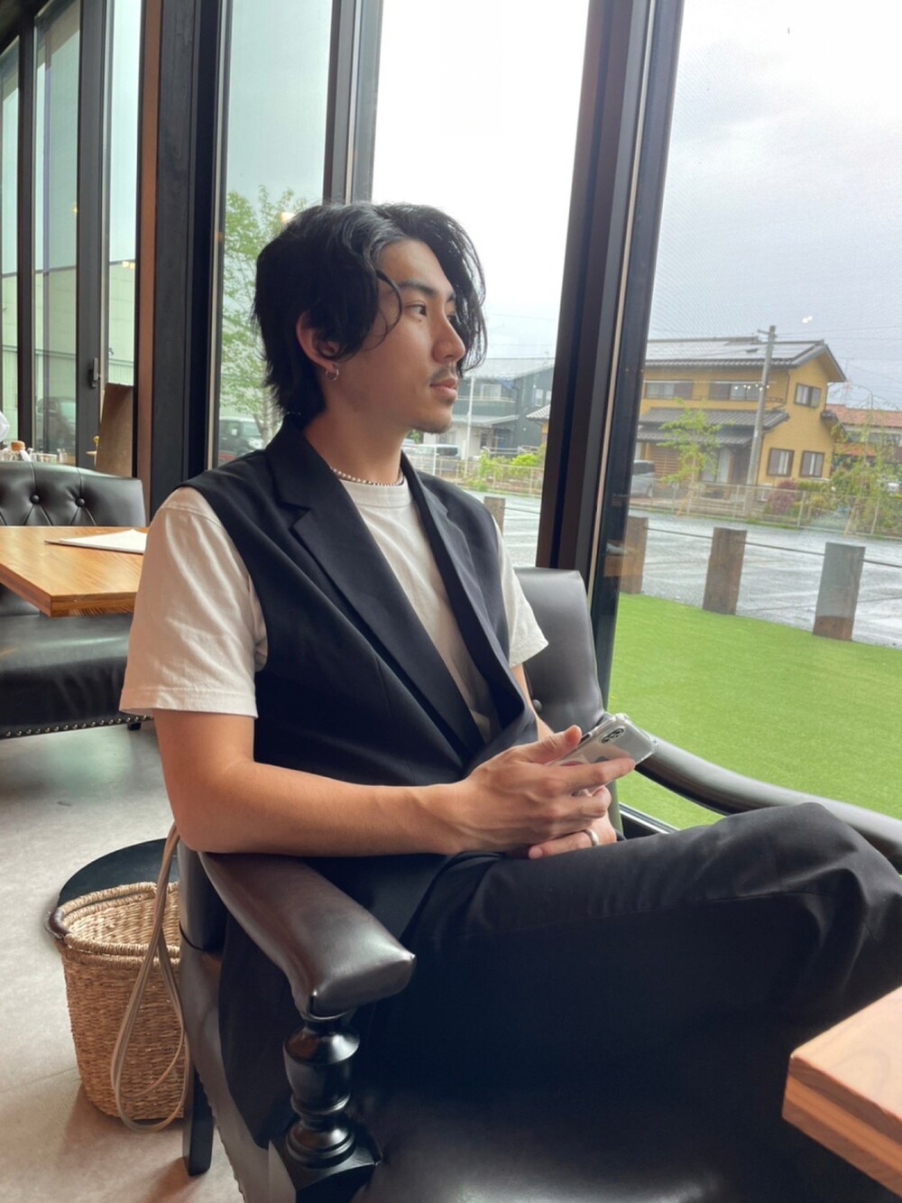 ブラック系のベスト、ブラック系のスラックス、ベージュ系のショルダーバッグを着用したメンズの春コーディネートの3枚目の写真