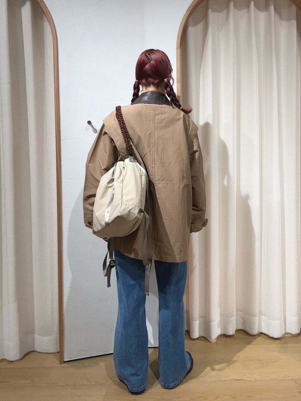 ブルー系のデニムパンツ、ベージュ系のその他アウター、ベージュ系のトートバッグを着用したレディースの秋コーディネートの2枚目の写真