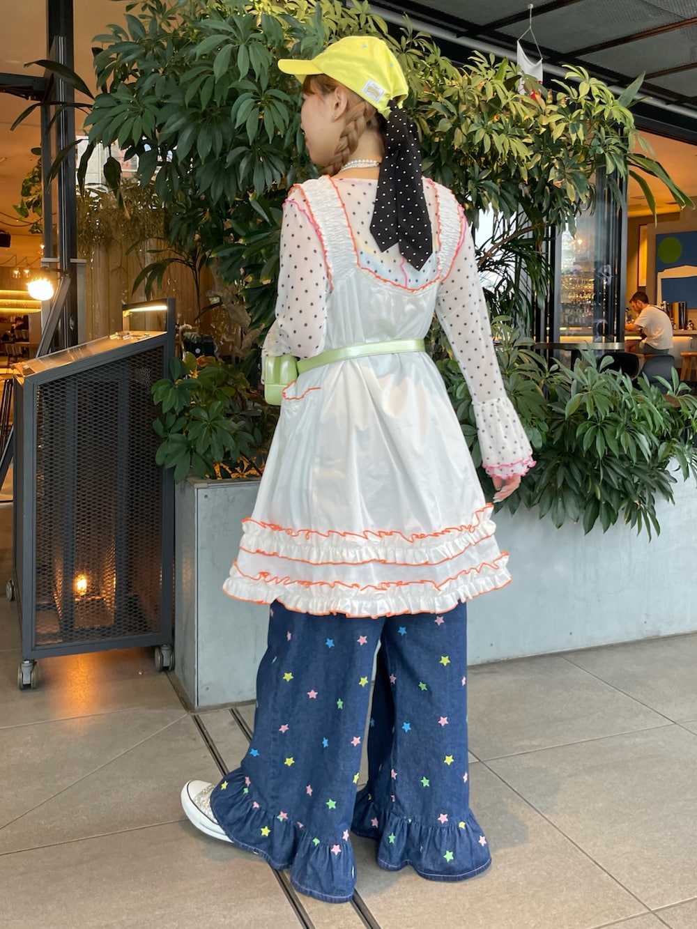 ホワイト系のTシャツ/カットソー、イエロー系のキャミソール、ブルー系のデニムパンツを着用したレディースの夏コーディネートの2枚目の写真