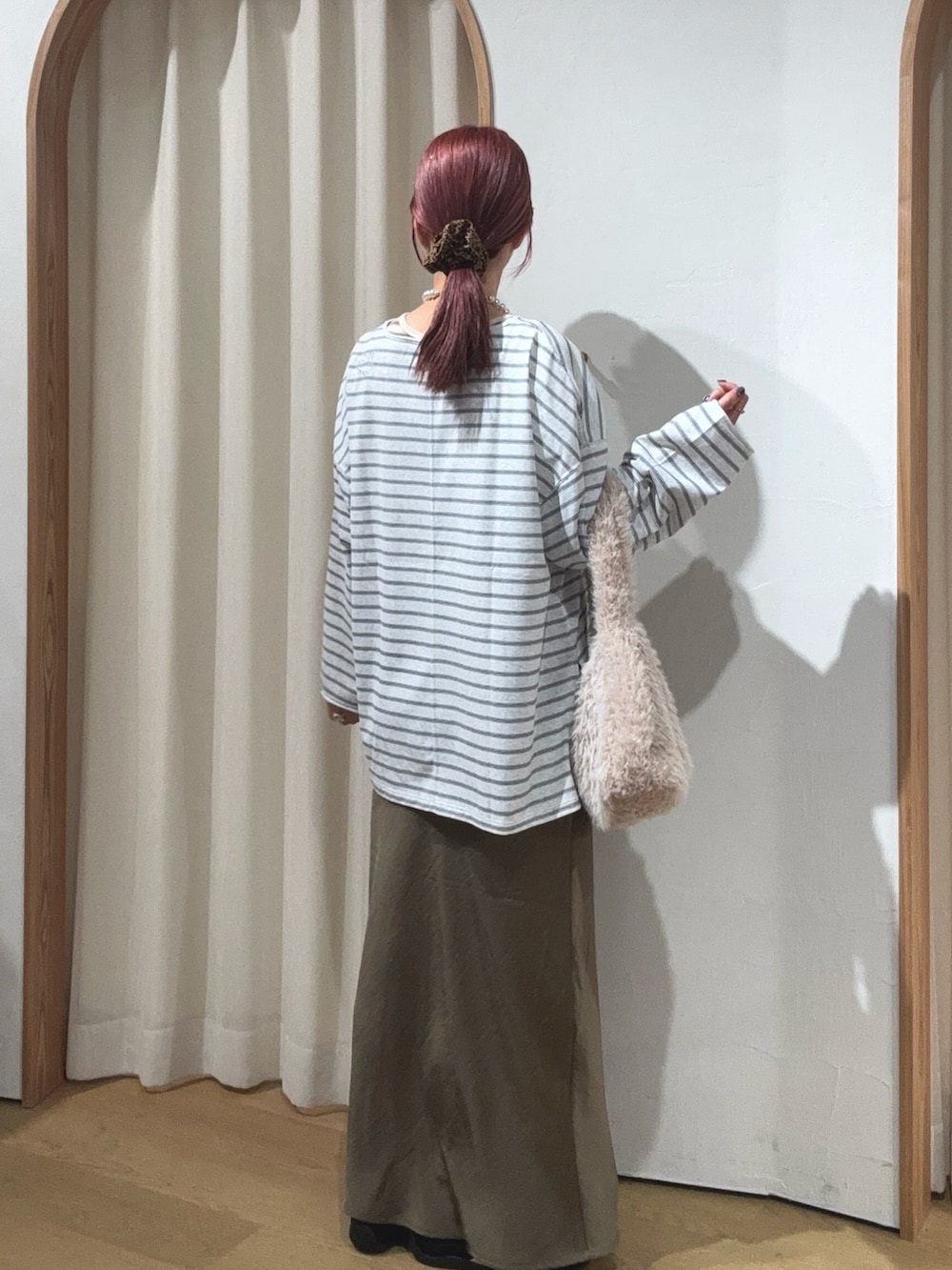 ホワイト系のトートバッグ、グリーン系のスカート、グレー系のTシャツ/カットソーを着用したレディースの秋コーディネートの2枚目の写真