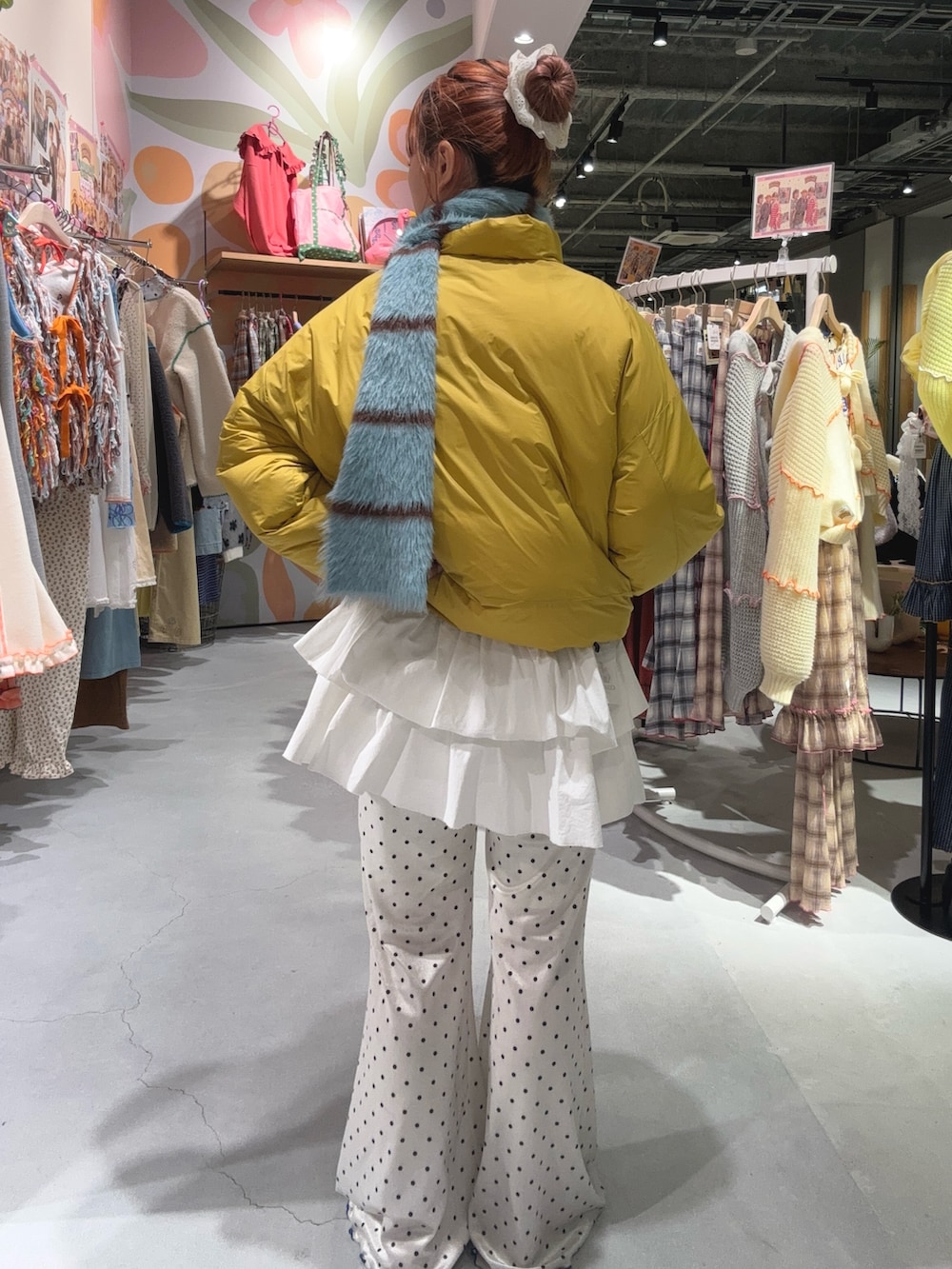 グレー系のTシャツ/カットソー、イエロー系のダウンジャケット/コート、ホワイト系のその他パンツを着用したレディースの冬コーディネートの2枚目の写真