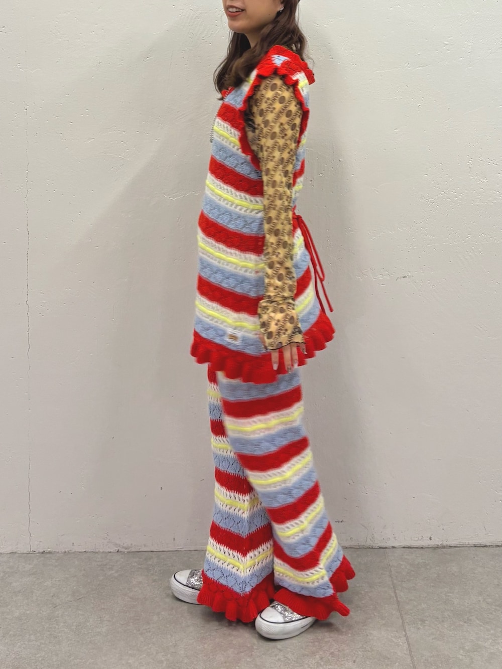 レッド系のニット/セーター、レッド系のその他パンツを着用したレディースの冬コーディネートの2枚目の写真