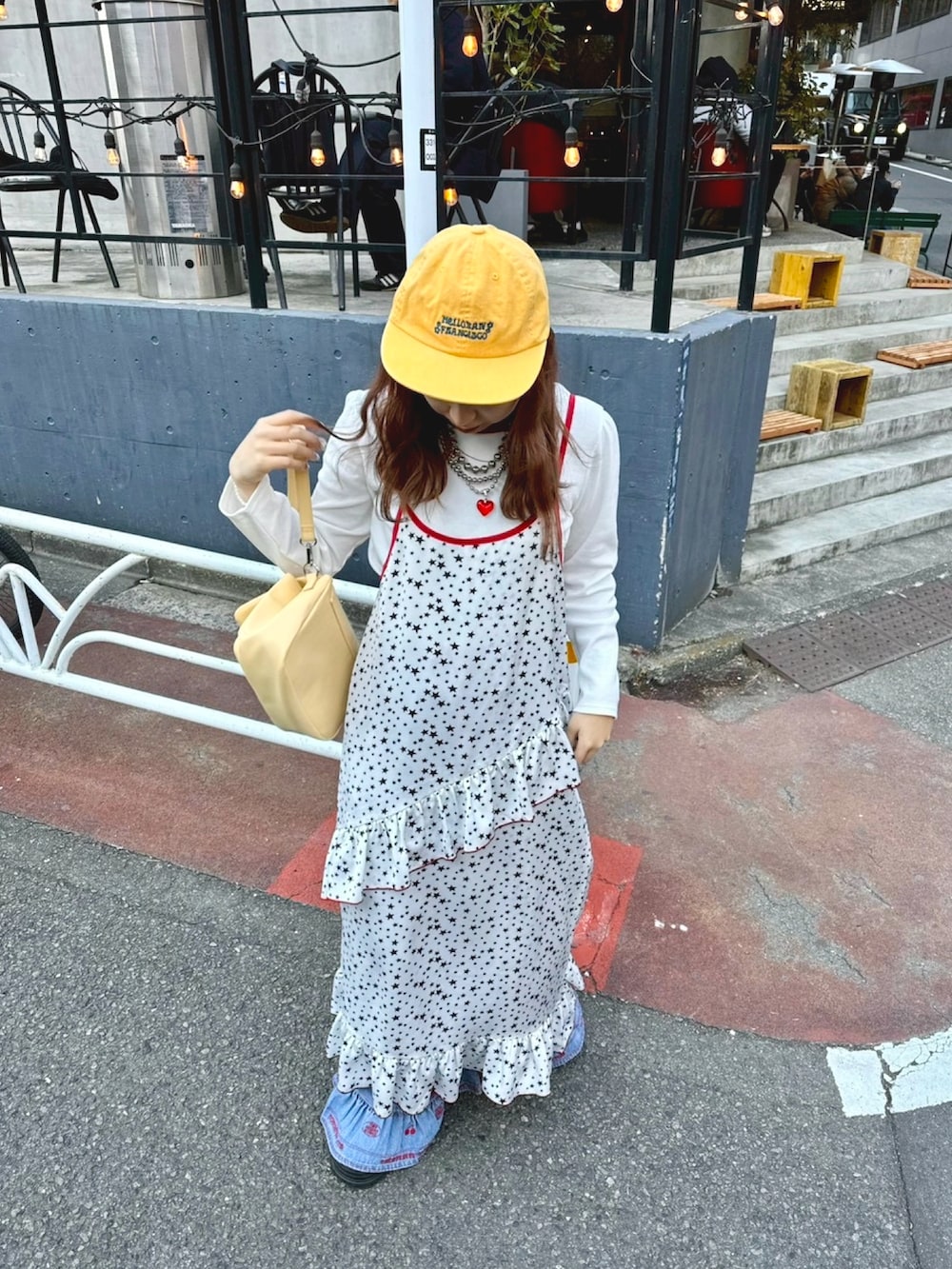 ホワイト系のワンピース、ブルー系のデニムパンツを着用したレディースの春コーディネートの2枚目の写真