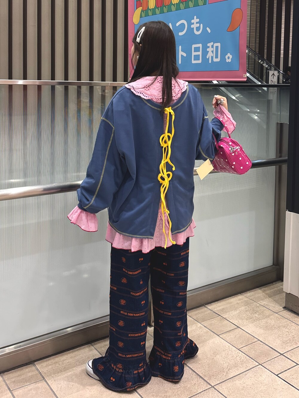 ピンク系のシャツ/ブラウス、ブルー系のTシャツ/カットソー、ピンク系のボストンバッグを着用したレディースの春コーディネートの2枚目の写真