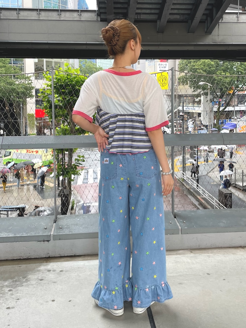 イエロー系のキャミソール、ホワイト系のTシャツ/カットソー、ブルー系のデニムパンツを着用したレディースの夏コーディネートの2枚目の写真