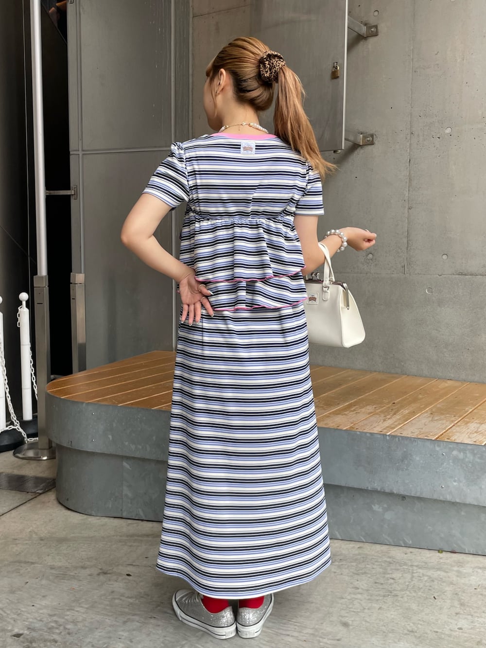 ブルー系のワンピース、ホワイト系のショルダーバッグを着用したレディースの夏コーディネートの2枚目の写真