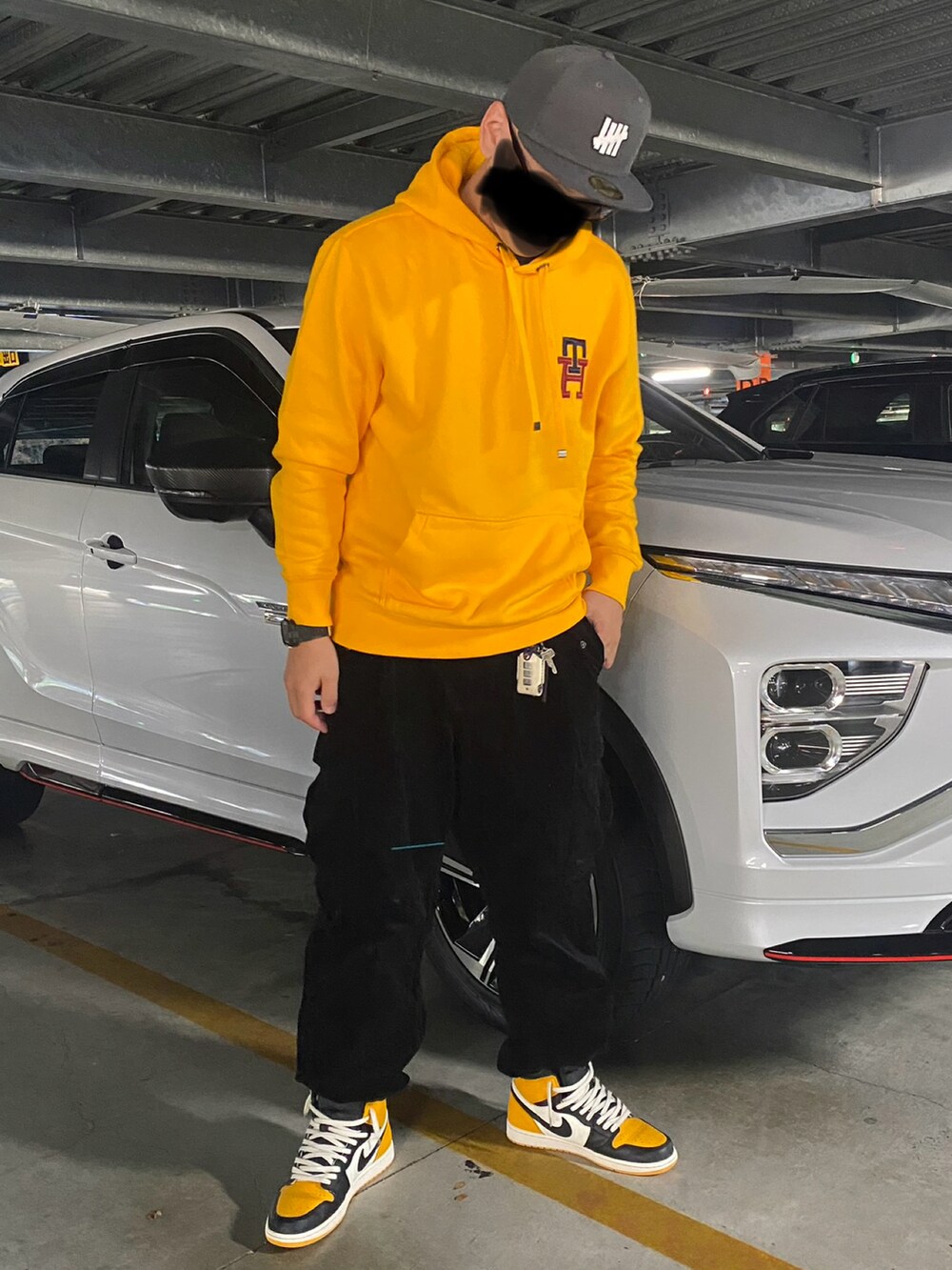 ブルー系のデニムジャケット、イエロー系のパーカー、ブラック系のカーゴパンツを着用したメンズの冬コーディネートの2枚目の写真