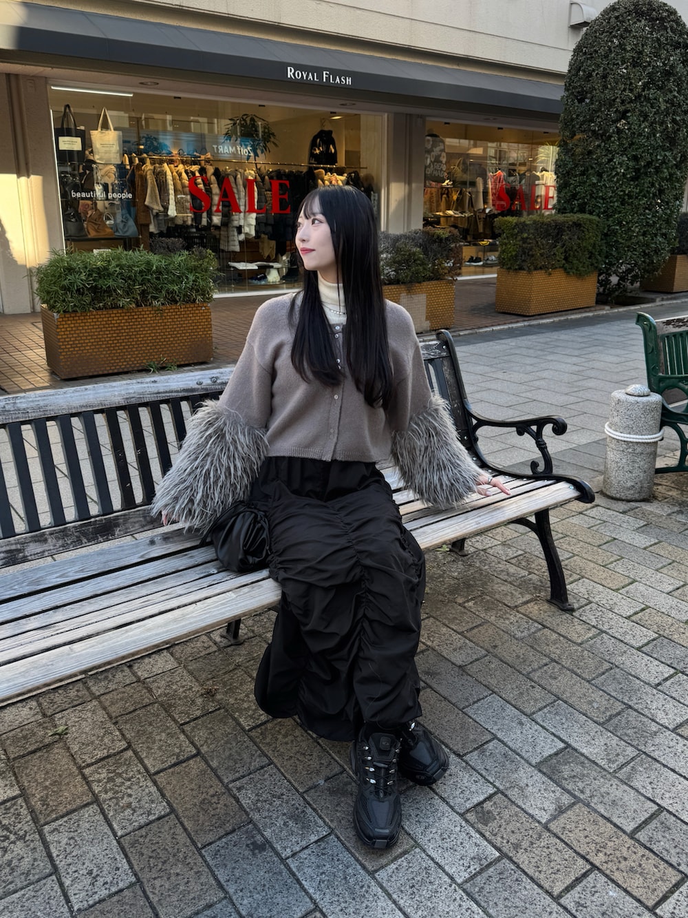 ブラック系のスニーカー、グレー系のニット/セーター、ホワイト系のニット/セーターを着用したレディースの冬コーディネートの2枚目の写真