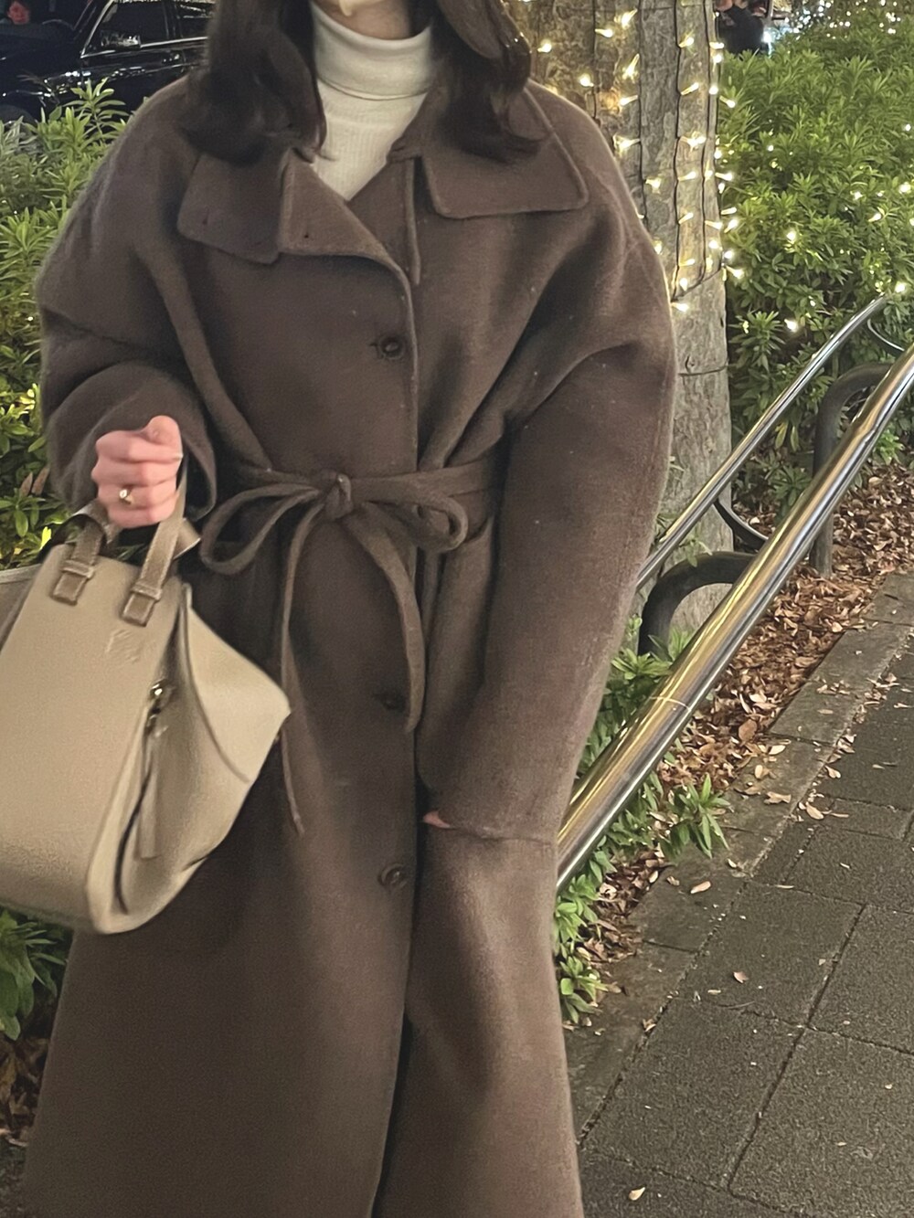 ベージュ系のハンドバッグ、ブラウン系のジャケット/アウター、ベージュ系のマフラーを着用したレディースの冬コーディネートの2枚目の写真