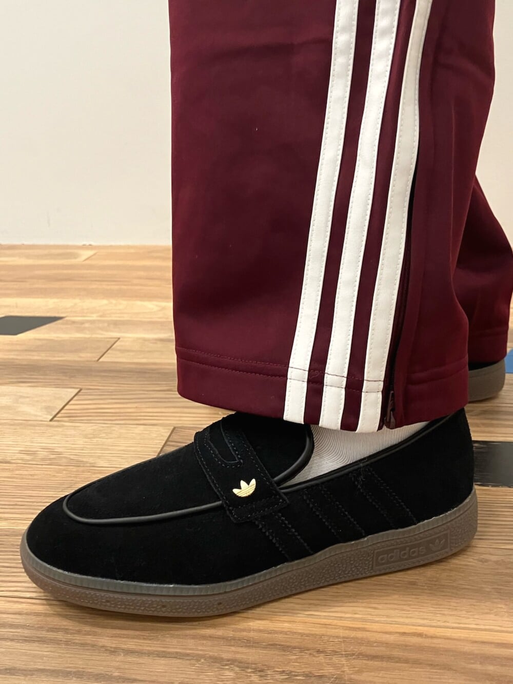 ブラック系のショルダーバッグ、レッド系のパンツ、ブラック系のスニーカーを着用したレディースの春コーディネートの2枚目の写真