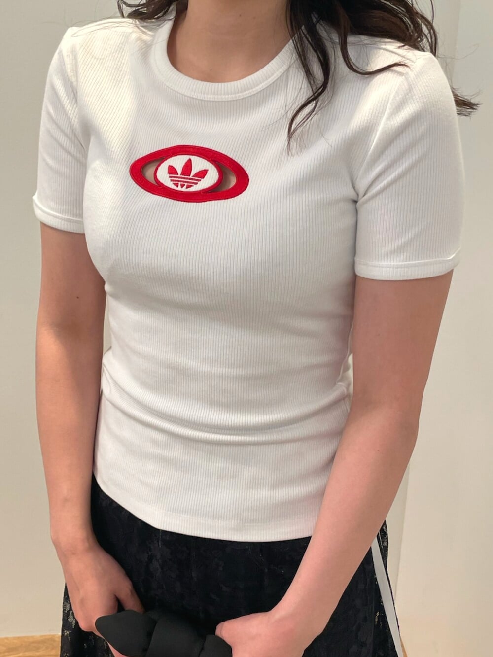 レッド系のスニーカー、ホワイト系のTシャツ/カットソー、ブラック系のハンドバッグを着用したレディースの夏コーディネートの2枚目の写真