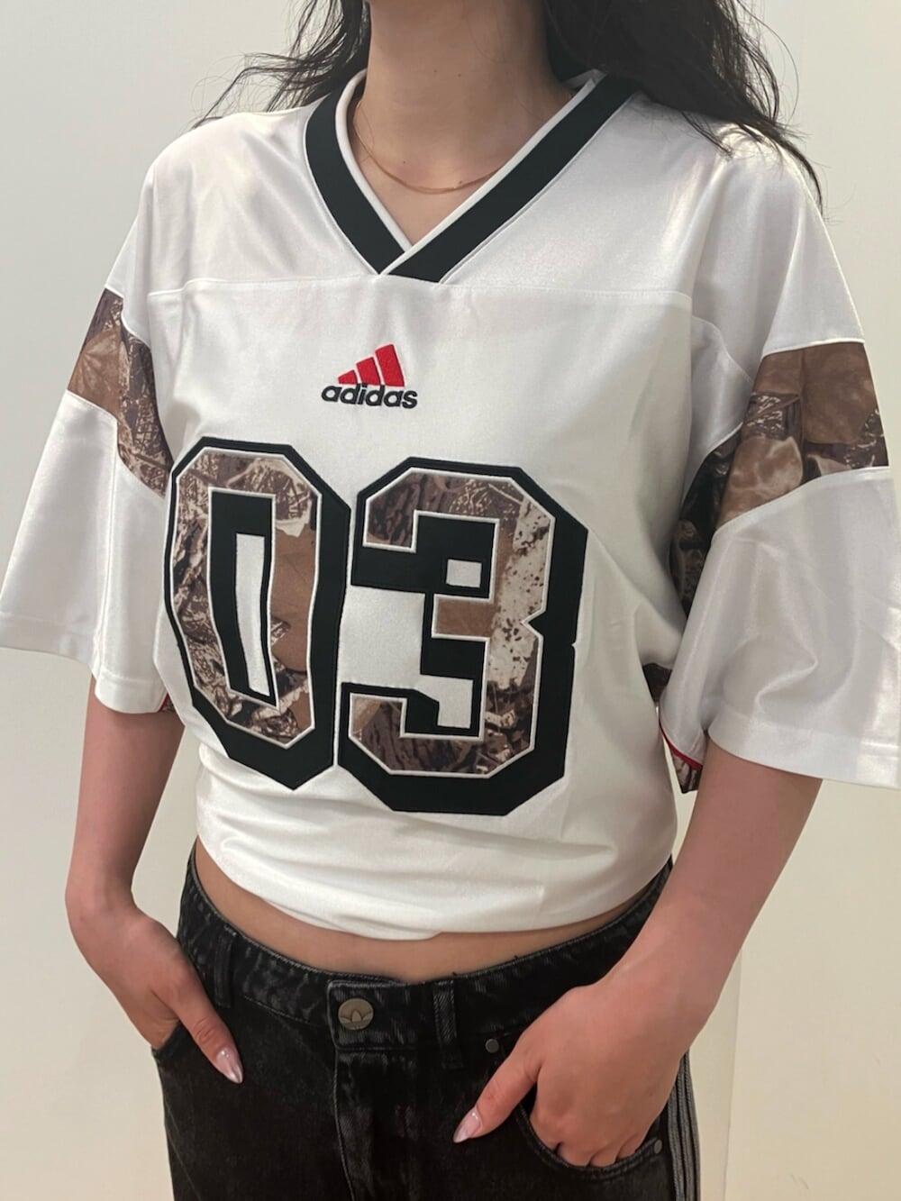 ホワイト系のトップス、ブラック系のデニムパンツ、ホワイト系のスニーカーを着用したレディースの夏コーディネートの2枚目の写真