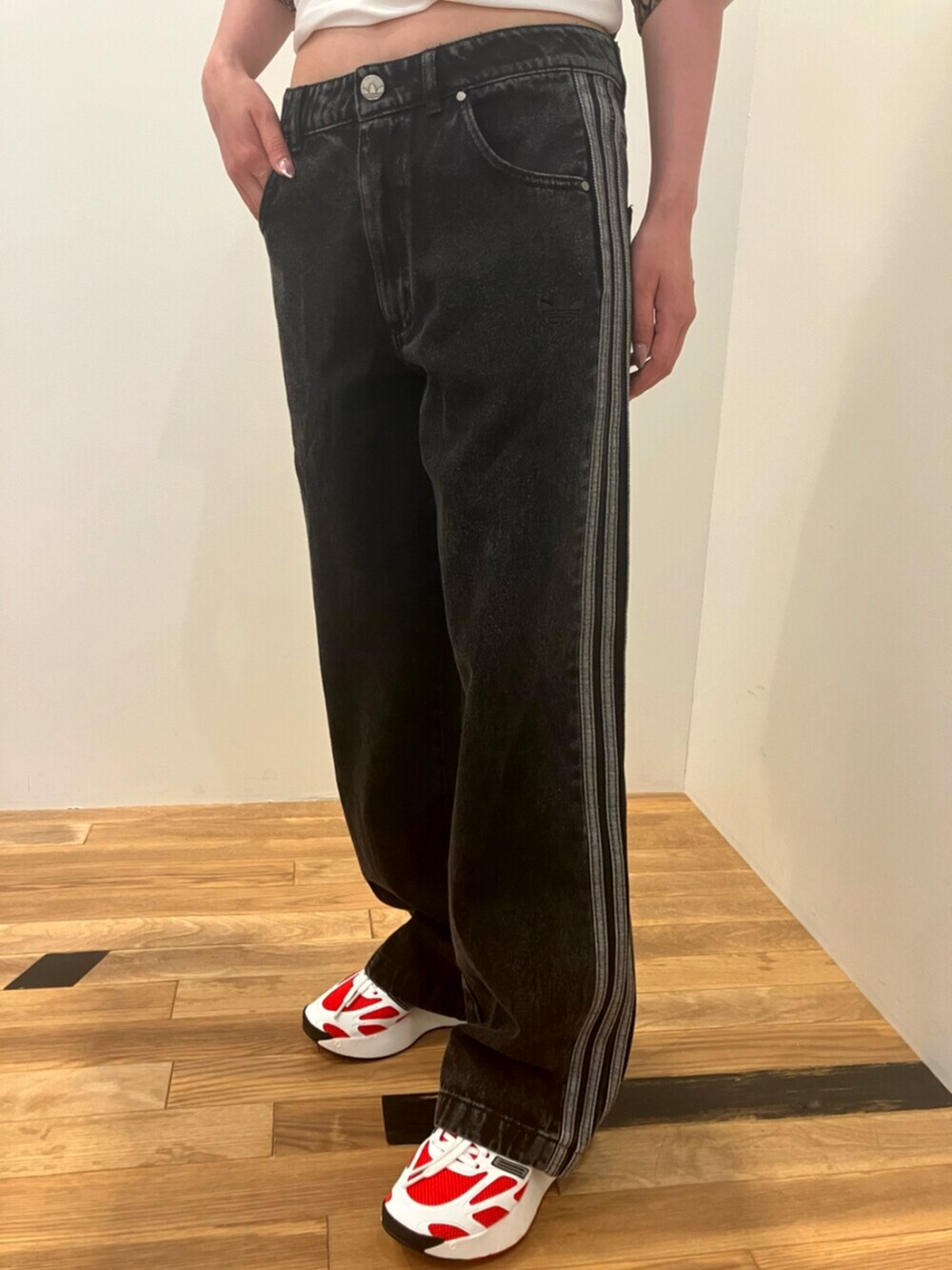 ホワイト系のトップス、ブラック系のデニムパンツ、ホワイト系のスニーカーを着用したレディースの夏コーディネートの3枚目の写真