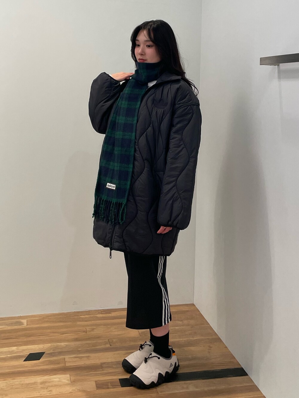 ブラック系のダウンジャケット/コート、ブラック系のスカート、ベージュ系のシューズを着用したレディースの秋コーディネートの2枚目の写真