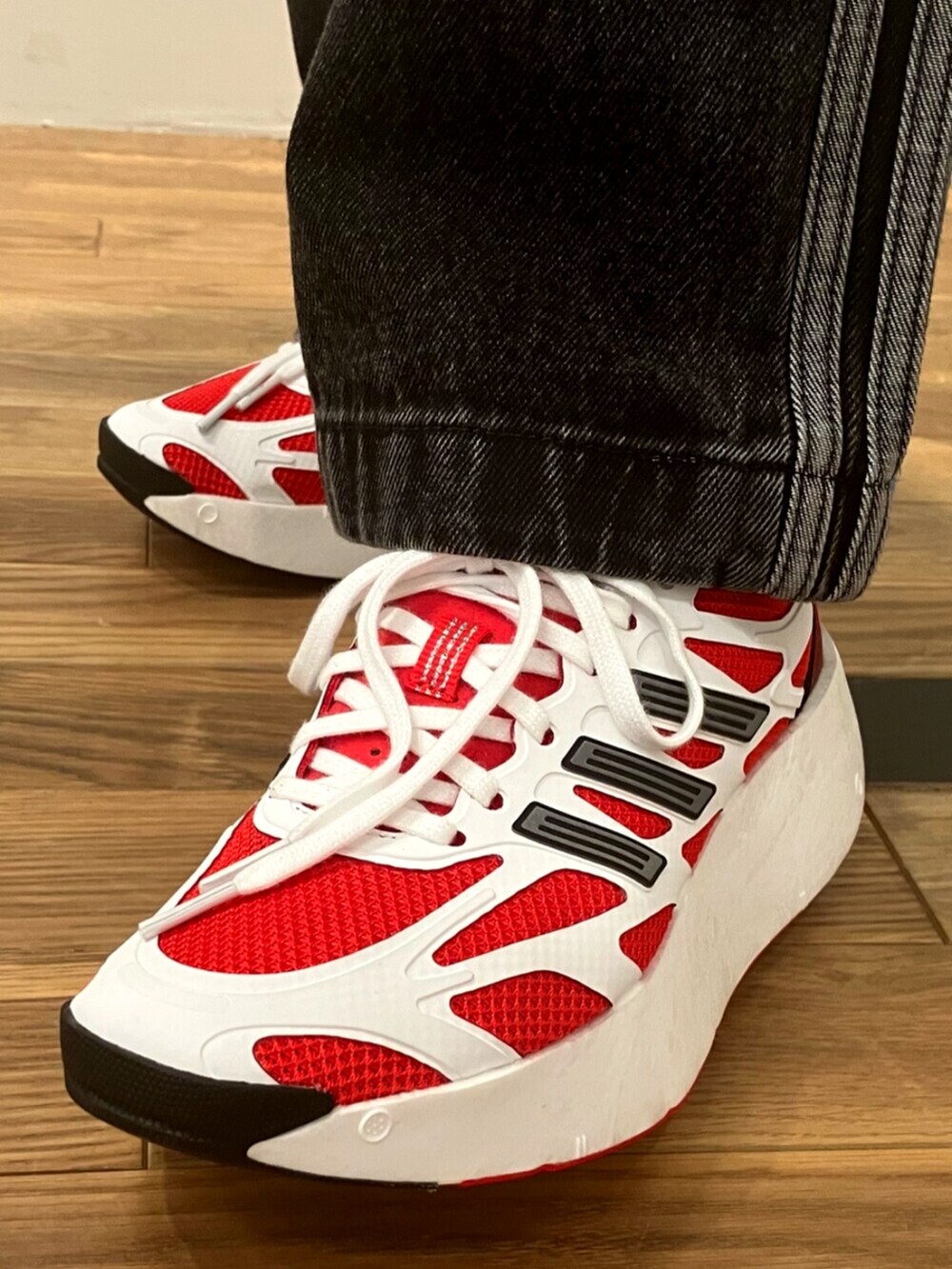 ホワイト系のトップス、ブラック系のデニムパンツ、ホワイト系のスニーカーを着用したレディースの夏コーディネートの4枚目の写真