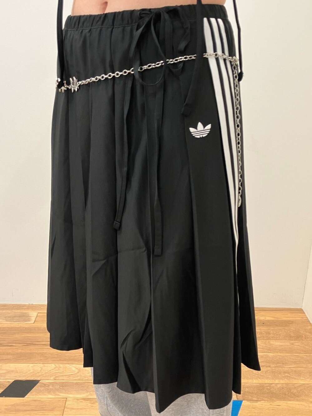 ブラック系のスニーカー、ブラック系のTシャツ/カットソー、ブラック系のスカートを着用したレディースの夏コーディネートの3枚目の写真