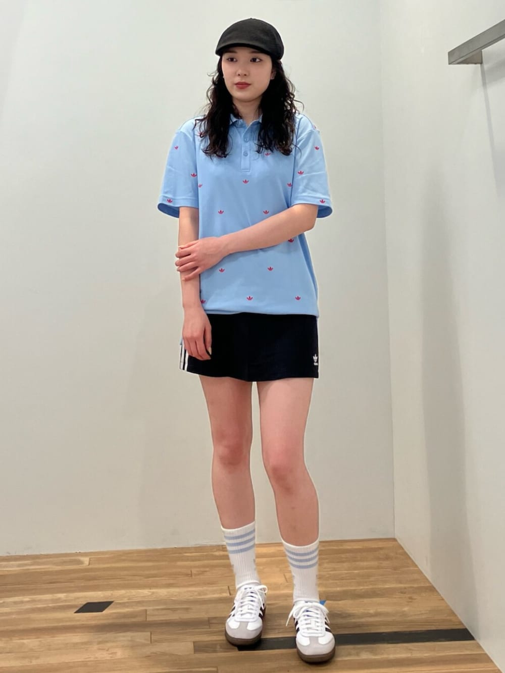 ホワイト系のシューズ、ブルー系のポロシャツ、ブラック系のスカートを着用したレディースの春コーディネートの2枚目の写真