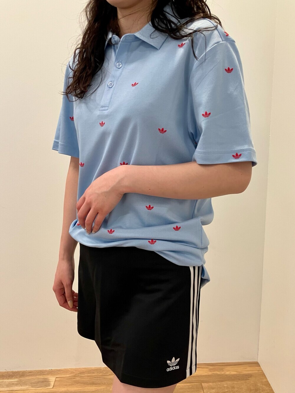 ホワイト系のシューズ、ブルー系のポロシャツ、ブラック系のスカートを着用したレディースの春コーディネートの3枚目の写真