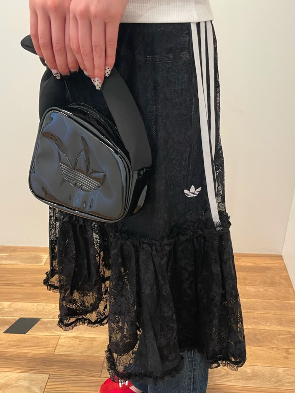 レッド系のスニーカー、ホワイト系のTシャツ/カットソー、ブラック系のハンドバッグを着用したレディースの夏コーディネートの3枚目の写真