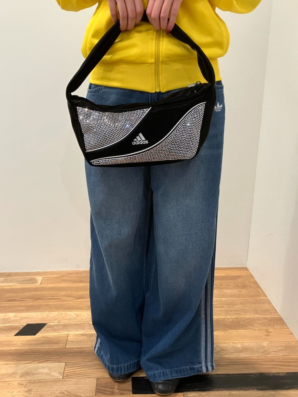 ブラック系のシューズ、イエロー系のジャージ、ブルー系のデニムパンツを着用したレディースの秋コーディネートの3枚目の写真