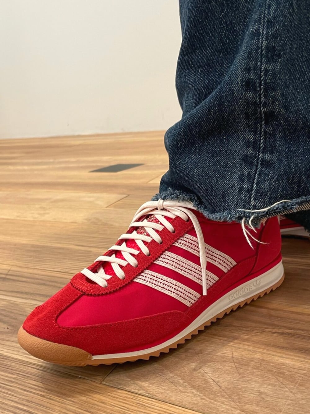 レッド系のスニーカー、ホワイト系のTシャツ/カットソー、ブラック系のハンドバッグを着用したレディースの夏コーディネートの4枚目の写真