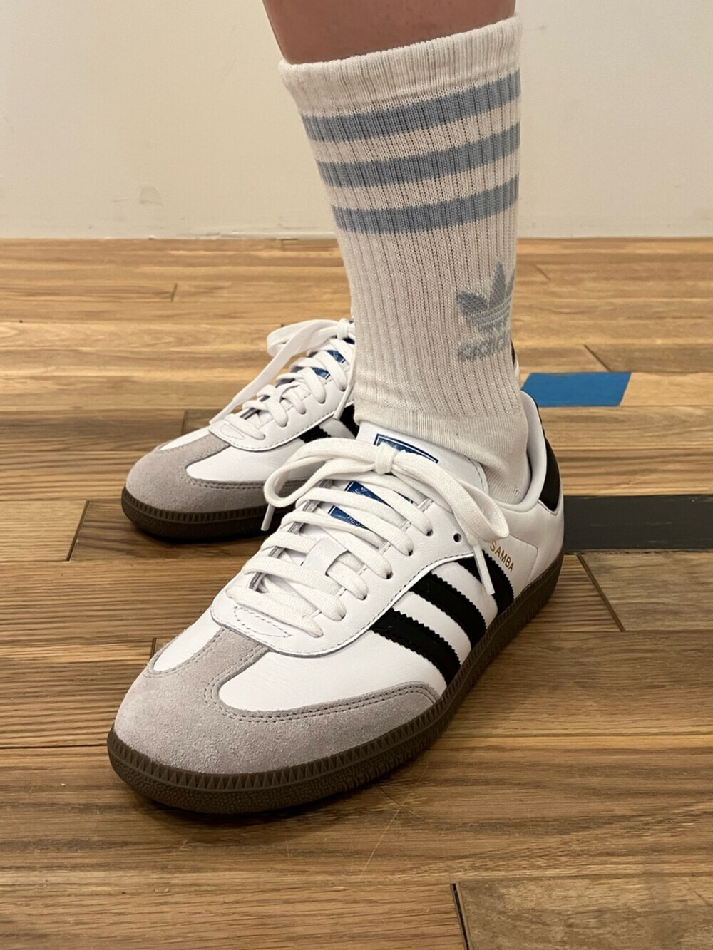 ホワイト系のシューズ、ブルー系のポロシャツ、ブラック系のスカートを着用したレディースの春コーディネートの4枚目の写真