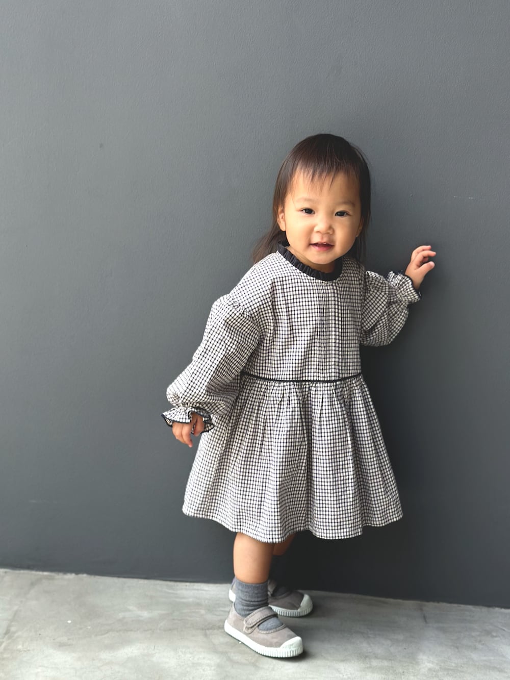 グレー系のワンピース、ブラウン系のスニーカーを着用したキッズの秋コーディネートの3枚目の写真