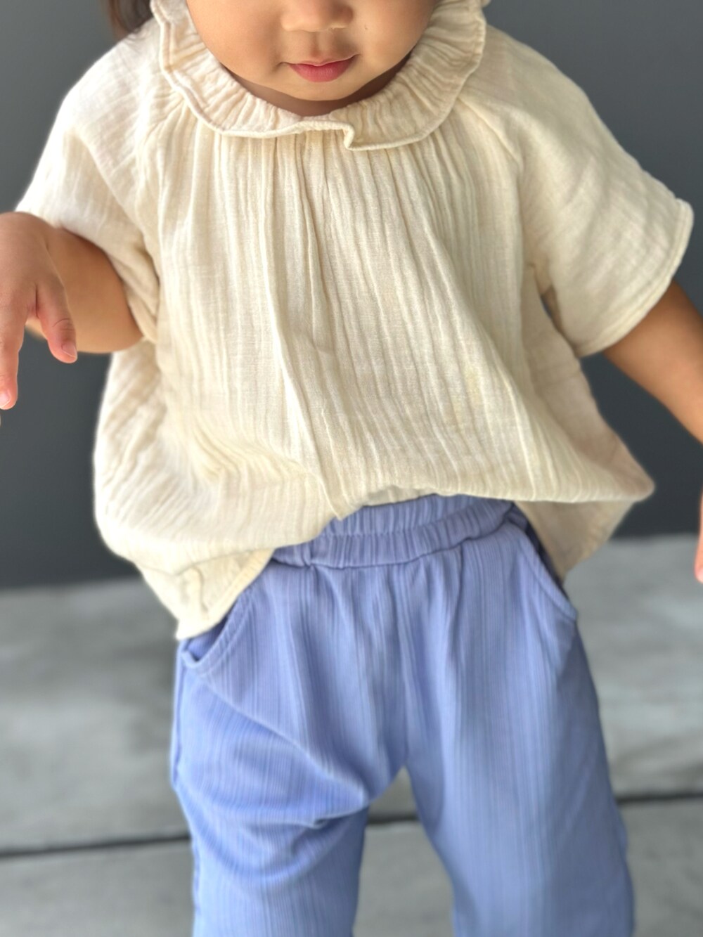 パープル系のその他パンツ、ベージュ系のシャツ/ブラウス、ブラック系のサンダルを着用したキッズの秋コーディネートの3枚目の写真