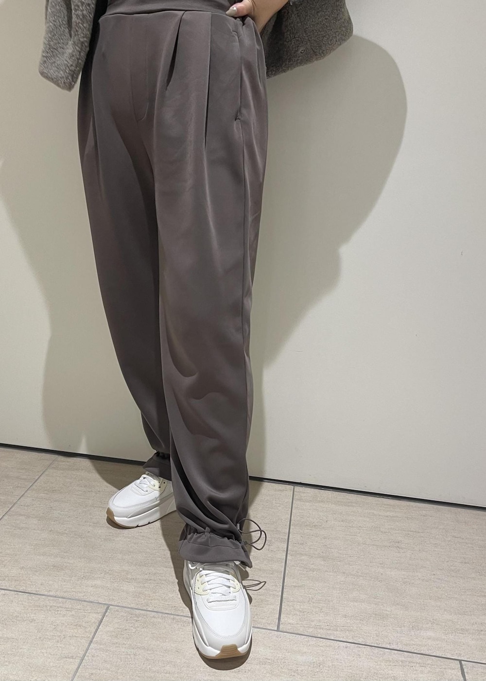 ベージュ系のその他アウター、ブラウン系のその他パンツ、ホワイト系のスニーカーを着用したレディースの秋コーディネートの5枚目の写真