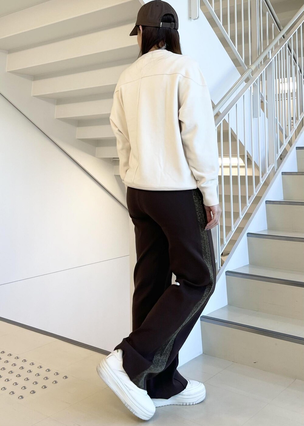 ブラウン系のその他パンツ、ホワイト系のスニーカー、ベージュ系のスウェットを着用したレディースの春コーディネートの2枚目の写真