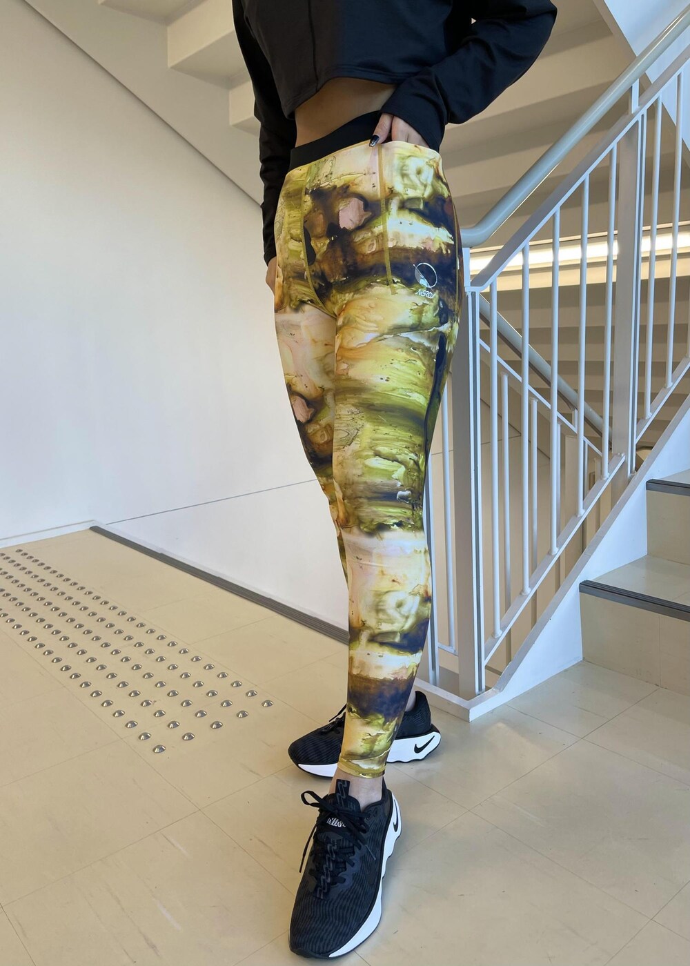 ブラック系のスニーカー、ブラック系のTシャツ/カットソー、イエロー系のレギンス/スパッツを着用したレディースの冬コーディネートの6枚目の写真