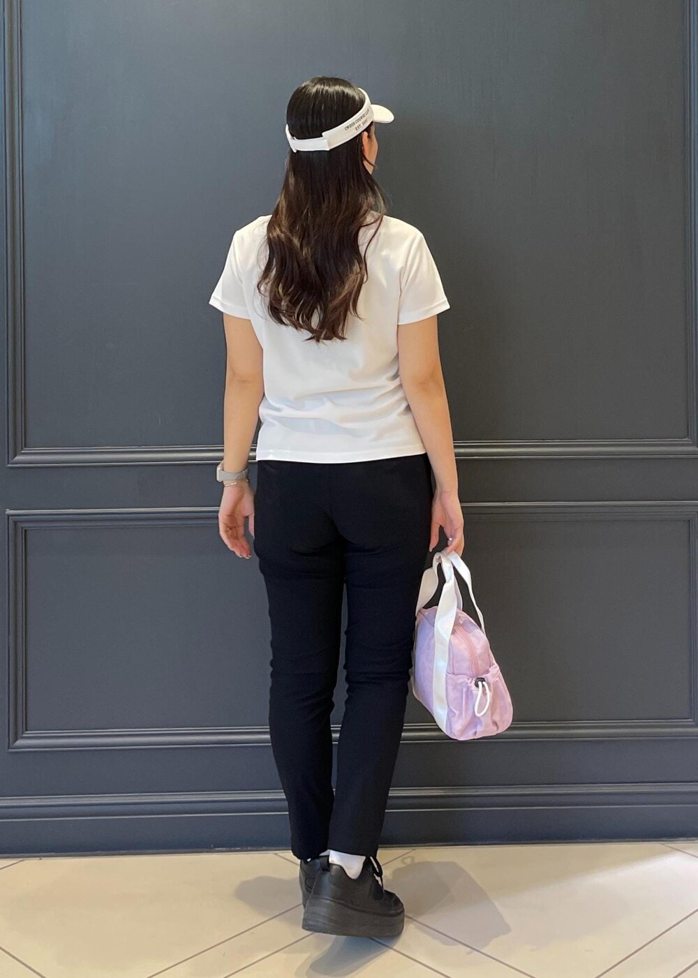 ブラック系のその他パンツ、ピンク系のポロシャツ、ピンク系のハンドバッグを着用したレディースの春コーディネートの2枚目の写真