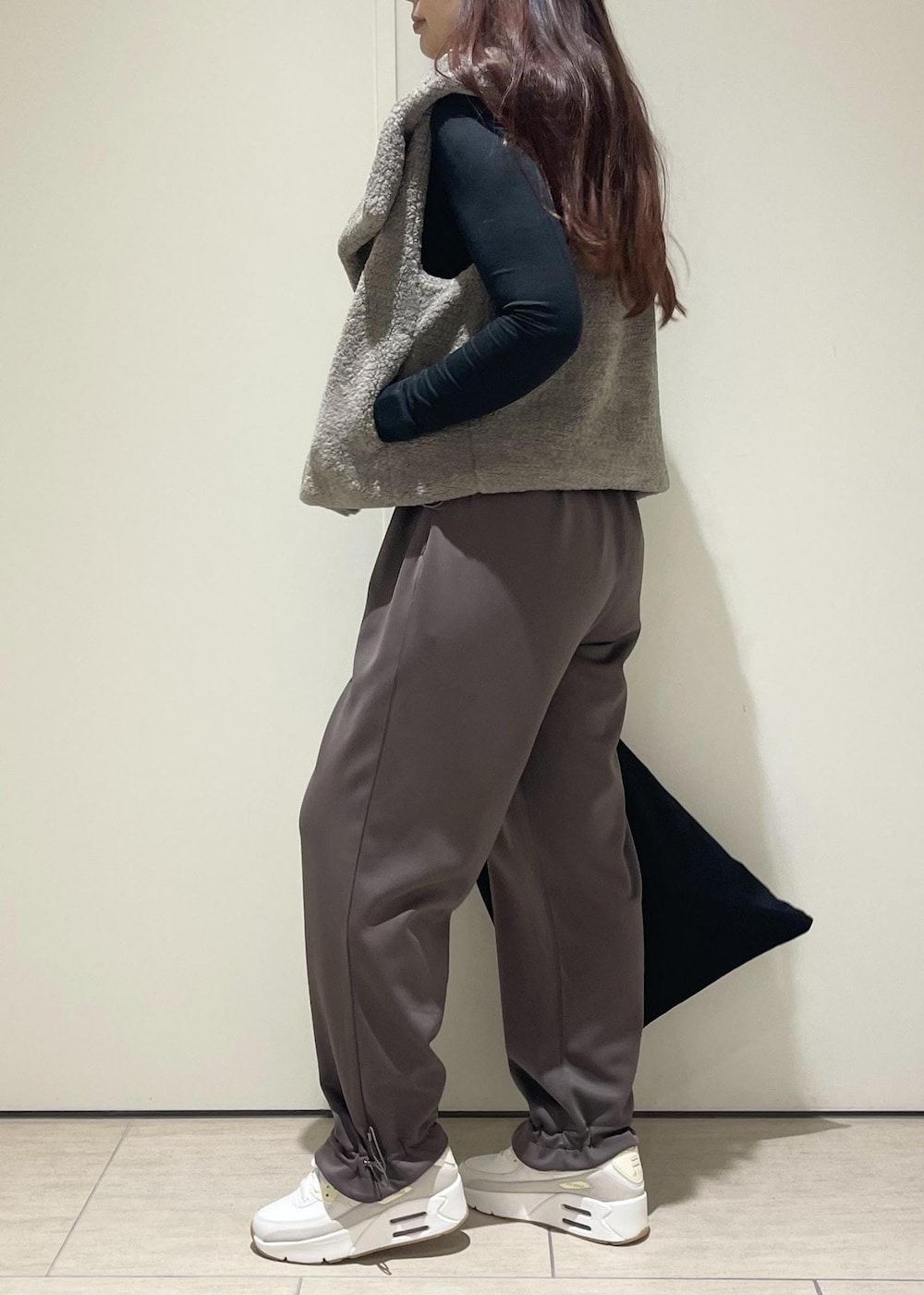 ベージュ系のその他アウター、ブラウン系のその他パンツ、ホワイト系のスニーカーを着用したレディースの秋コーディネートの2枚目の写真