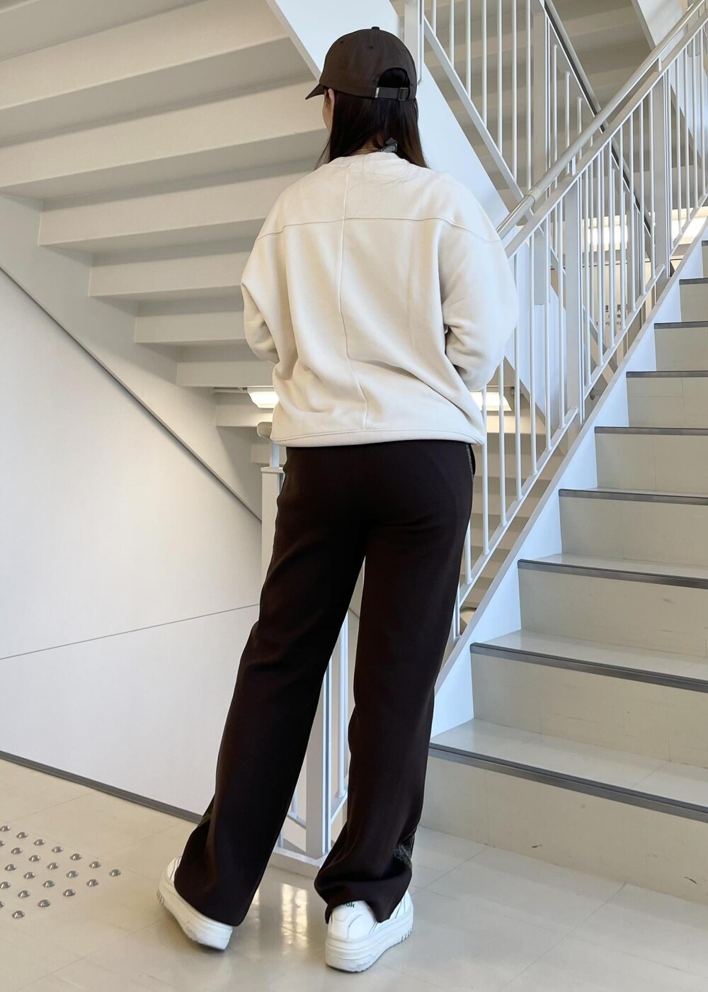 ブラウン系のその他パンツ、ホワイト系のスニーカー、ベージュ系のスウェットを着用したレディースの春コーディネートの3枚目の写真