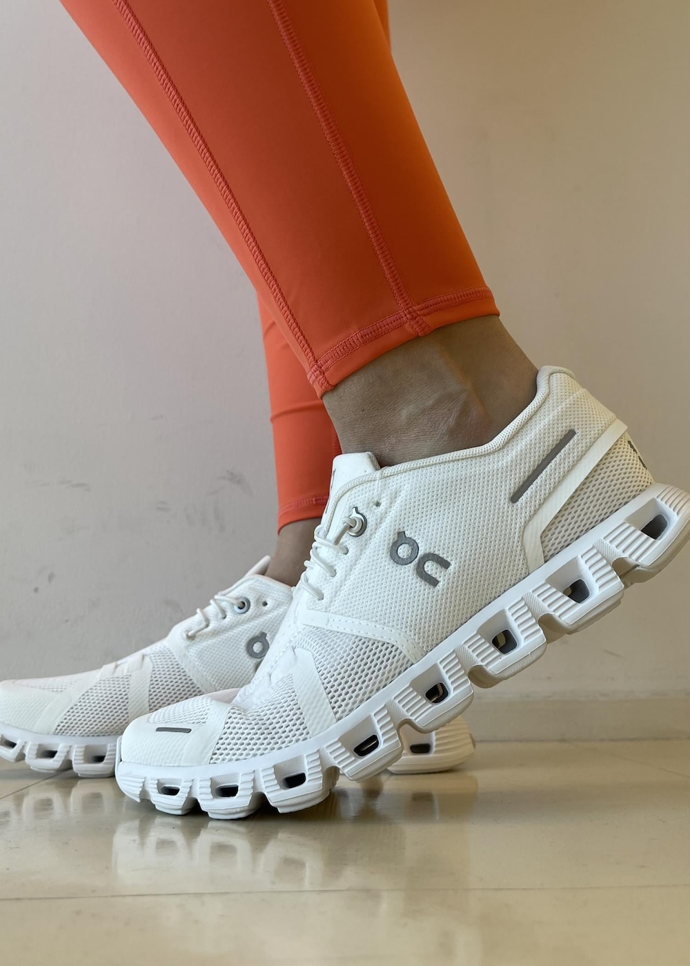 ホワイト系のスニーカー、ベージュ系のスウェット、オレンジ系のレギンス/スパッツを着用したレディースの春コーディネートの6枚目の写真