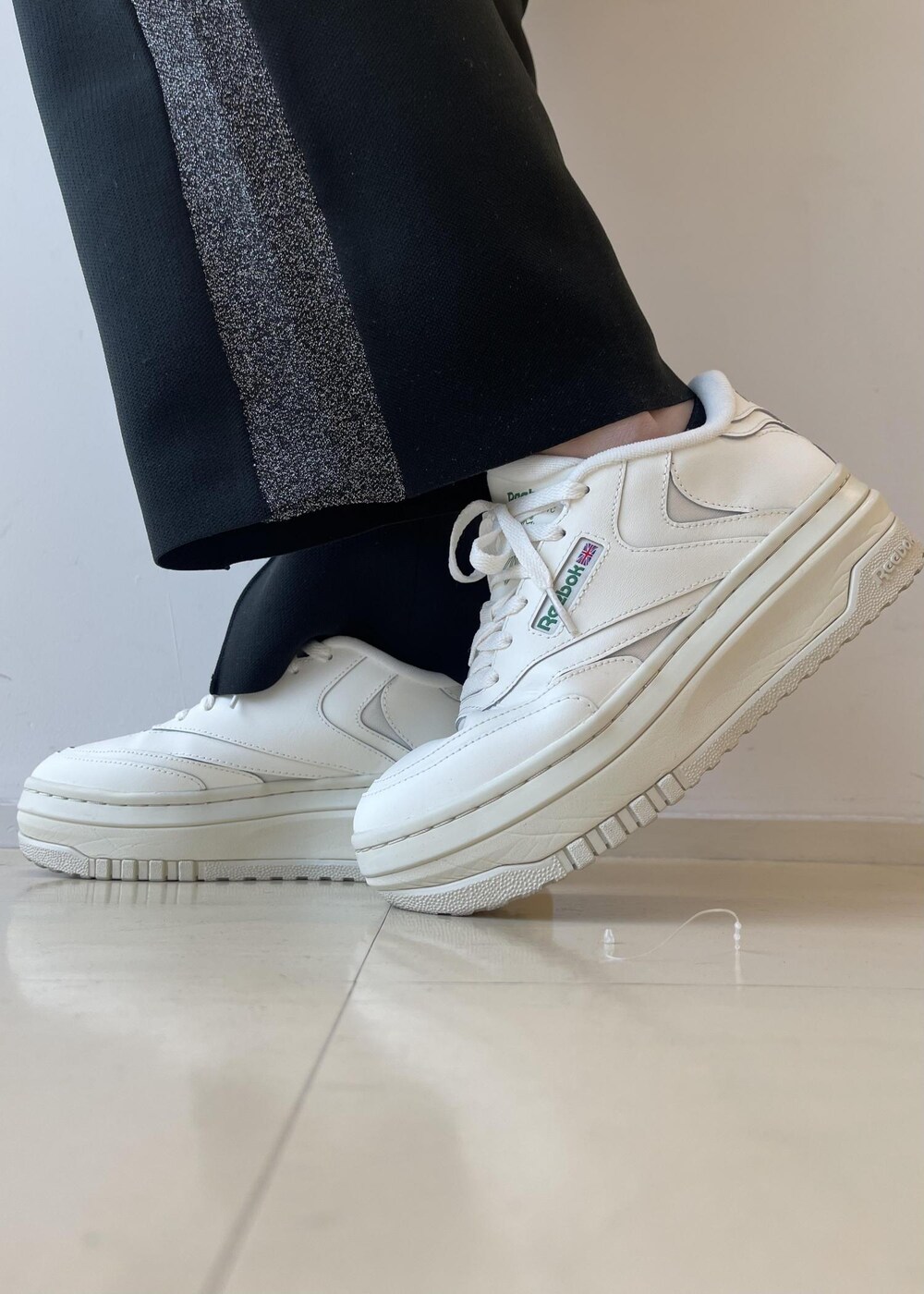 ブラック系のカーディガン/ボレロ、ホワイト系のスニーカー、ブラック系のその他パンツを着用したレディースの冬コーディネートの6枚目の写真