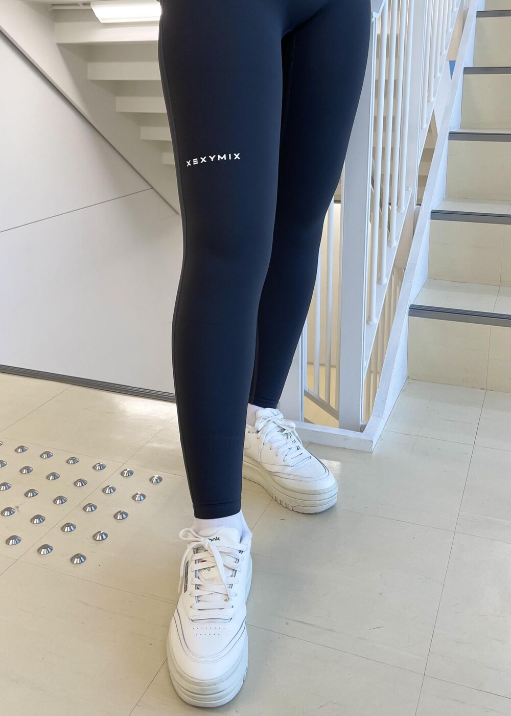 ホワイト系のスニーカー、グリーン系のスウェット、グレー系のレギンス/スパッツを着用したレディースの冬コーディネートの5枚目の写真