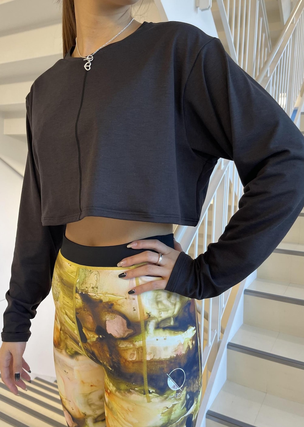 ブラック系のスニーカー、ブラック系のTシャツ/カットソー、イエロー系のレギンス/スパッツを着用したレディースの冬コーディネートの5枚目の写真