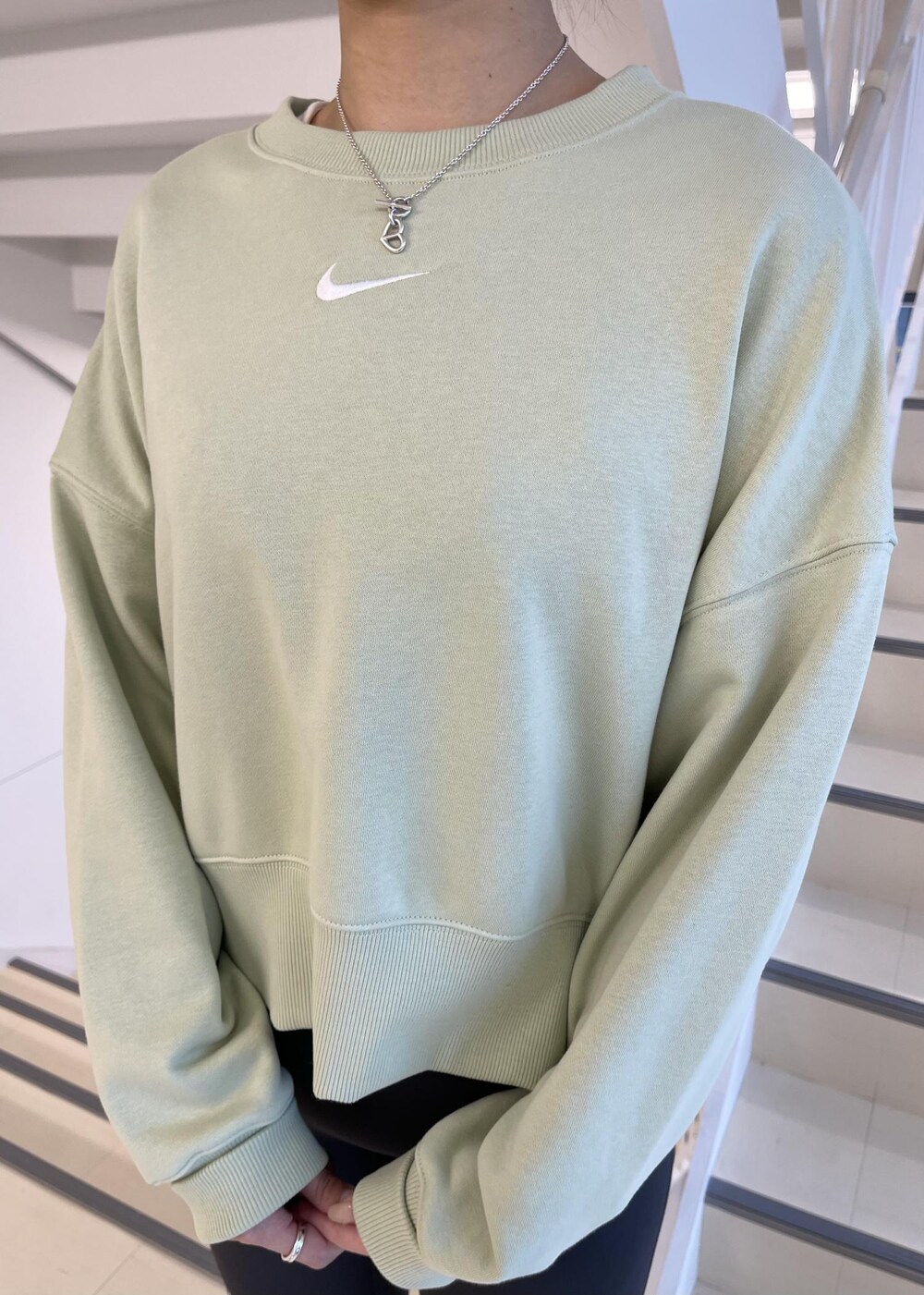 ホワイト系のスニーカー、グリーン系のスウェット、グレー系のレギンス/スパッツを着用したレディースの冬コーディネートの4枚目の写真