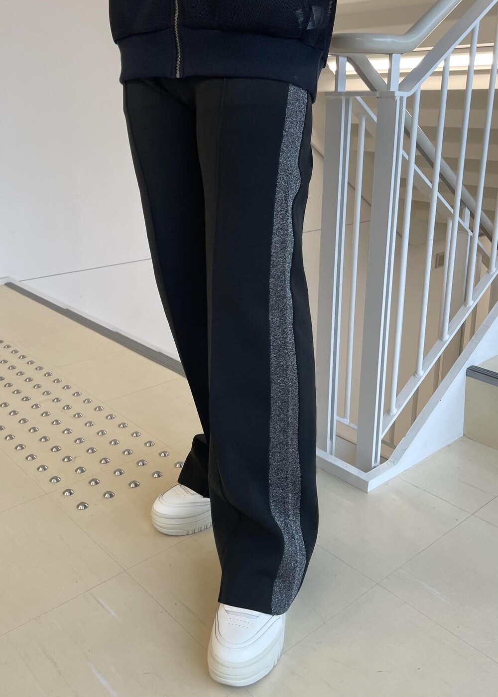 ブラック系のカーディガン/ボレロ、ホワイト系のスニーカー、ブラック系のその他パンツを着用したレディースの冬コーディネートの5枚目の写真