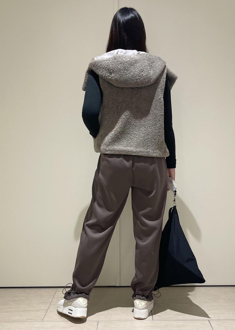 ベージュ系のその他アウター、ブラウン系のその他パンツ、ホワイト系のスニーカーを着用したレディースの秋コーディネートの3枚目の写真