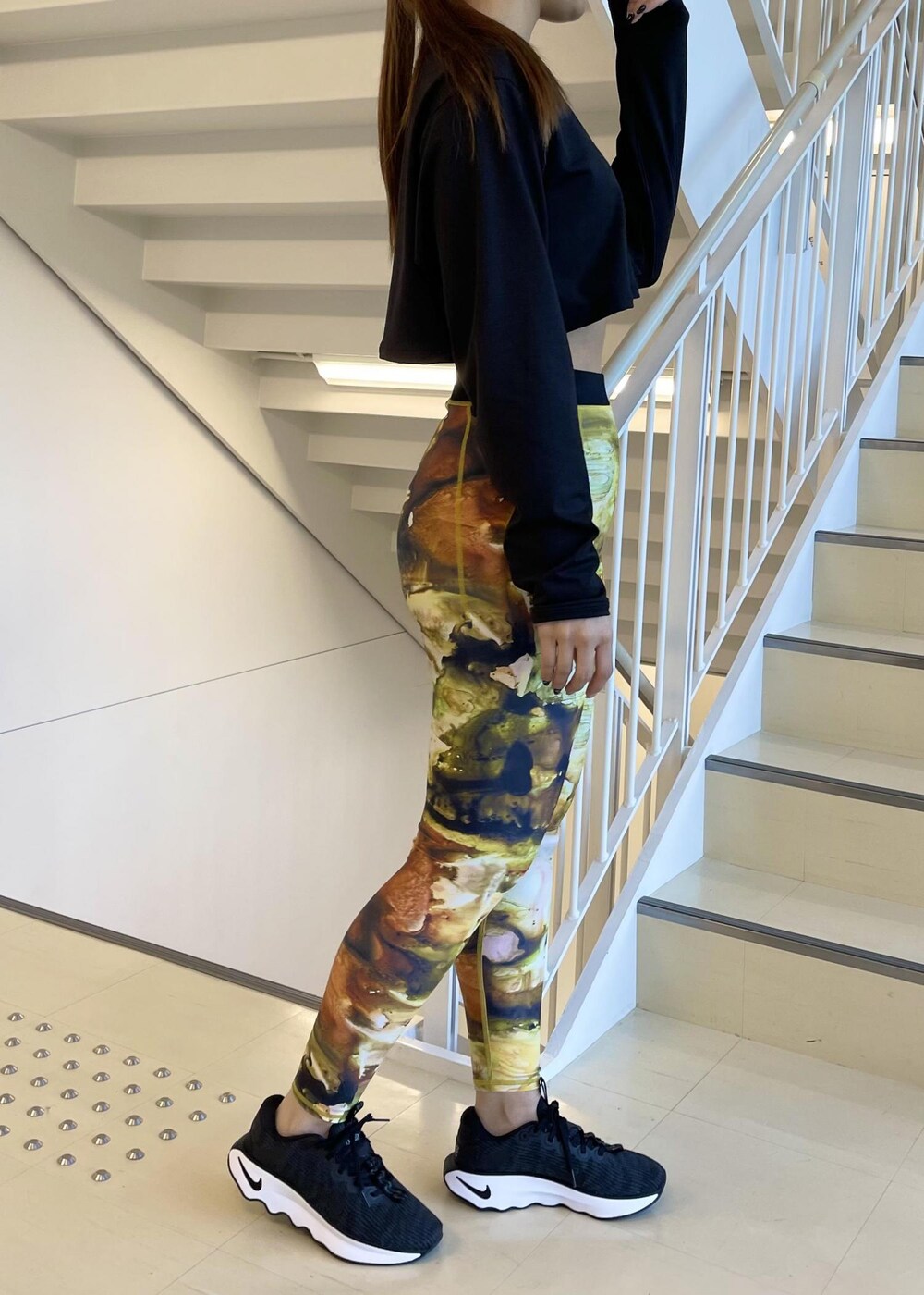 ブラック系のスニーカー、ブラック系のTシャツ/カットソー、イエロー系のレギンス/スパッツを着用したレディースの冬コーディネートの2枚目の写真