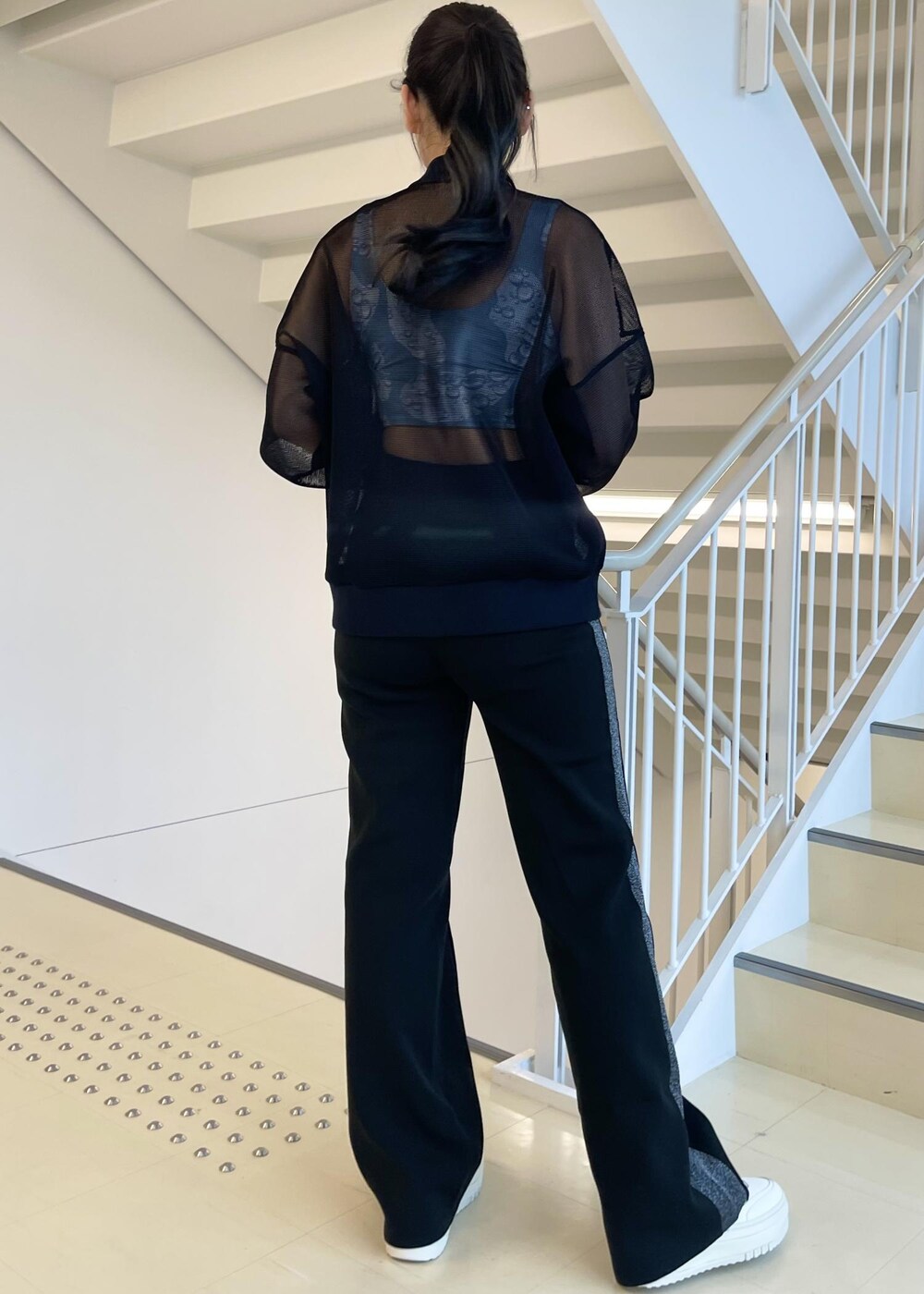 ブラック系のカーディガン/ボレロ、ホワイト系のスニーカー、ブラック系のその他パンツを着用したレディースの冬コーディネートの3枚目の写真