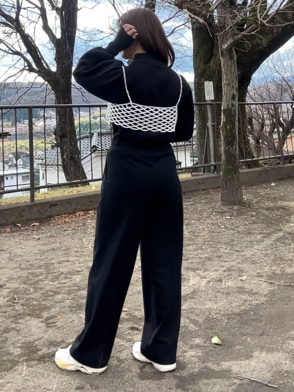 レッド系のトートバッグ、ブラック系のジャケット/アウター、ブラック系のパンツを着用したレディースの冬コーディネートの2枚目の写真