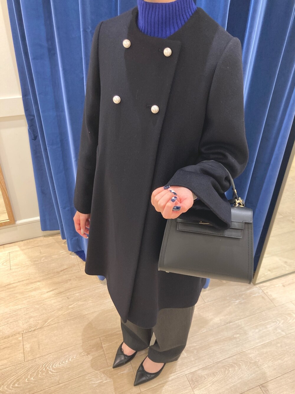 ブルー系のその他アウター、ブルー系のニット/セーター、ブラック系のパンプスを着用したレディースの冬コーディネートの5枚目の写真